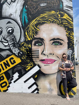 A person stands in front of a mural featuring Rachel McAdams