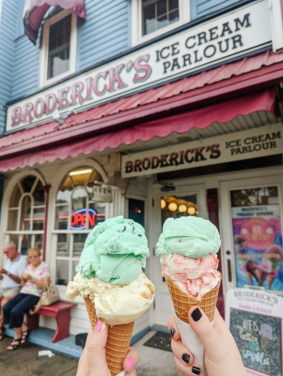 two people holding ice cream cones in front of the vintage looking ice cream parlour, Brodericks' in Port Stanley